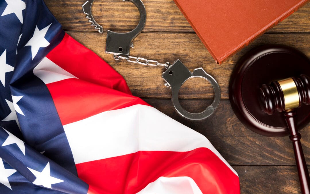 top view of a court table with american flag, handcuffs and gavel-scaled